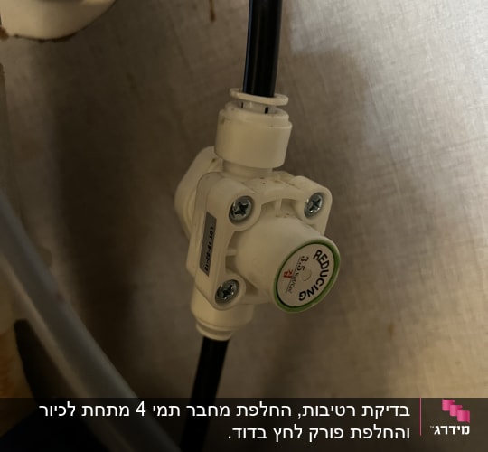 שסתום פלסטיק עם צינור שחור מתחת לכיור